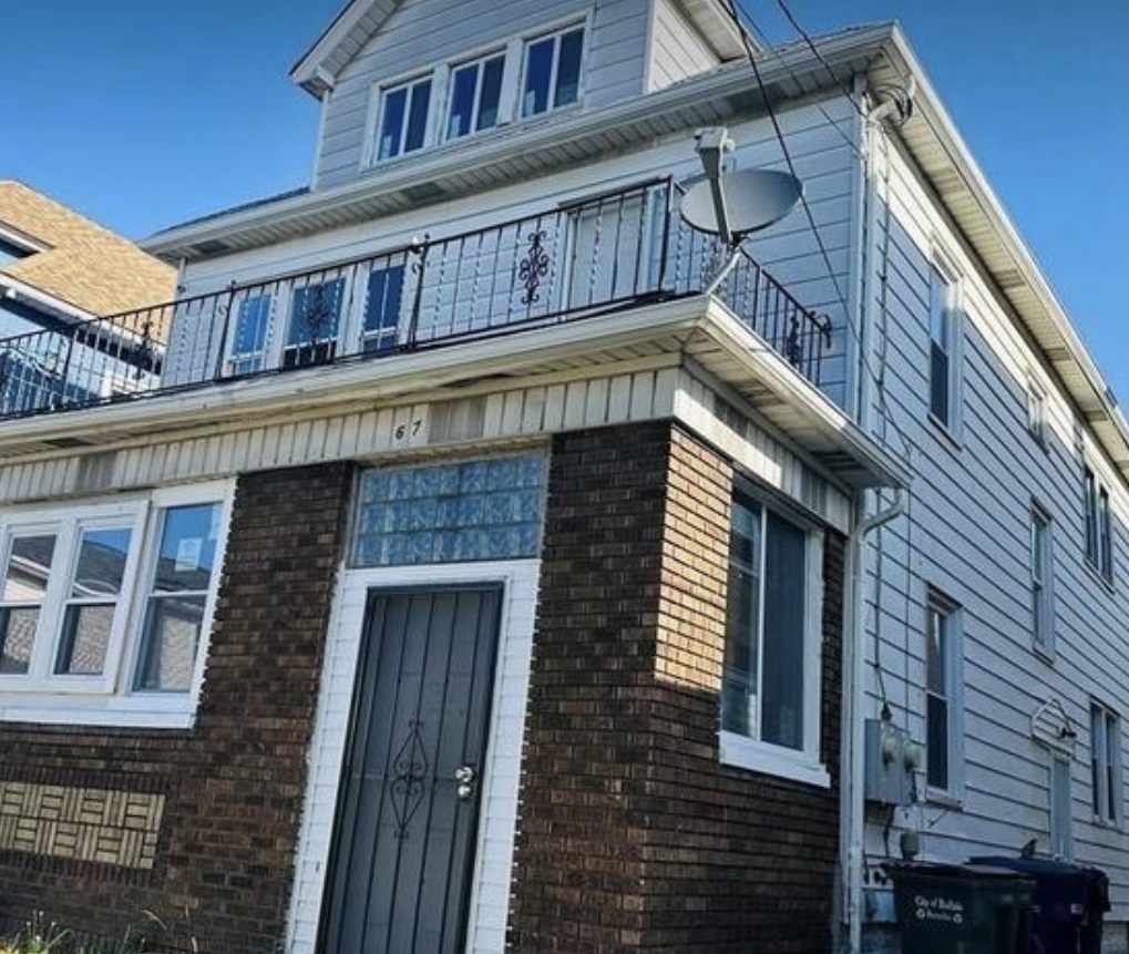 Two-family home with brick facade and upper balcony, managed by WNY RPM Solution in Buffalo, New York