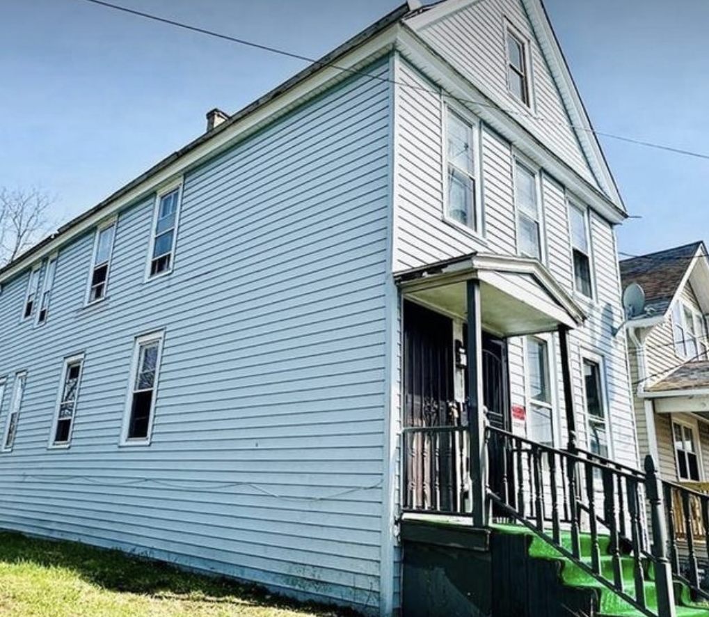 Pale blue two-storey rental property with a covered porch in Western New York